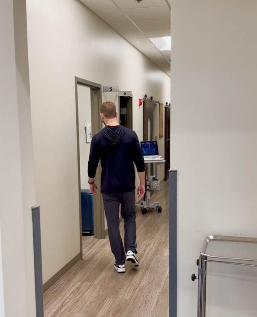 PA standing outside patient room preparing to explain clinical uncertainty to a patient
