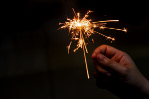 Lit sparkler held by hand at night — firework burns are more dangerous than they look